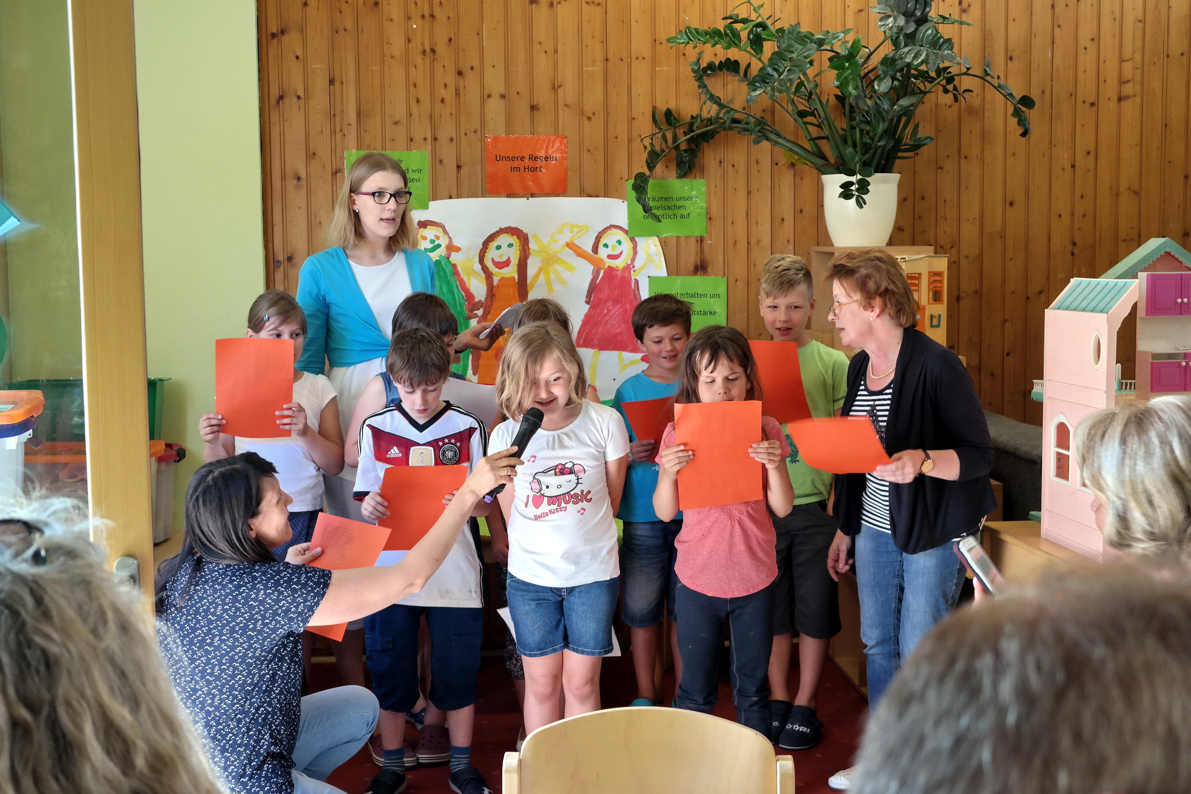 Die drei Erzieherinnen Gudrun Bauer, Katrin Otte und Elena Hoffmann zusammen mit den Hortkindern beim Begrüßungslied