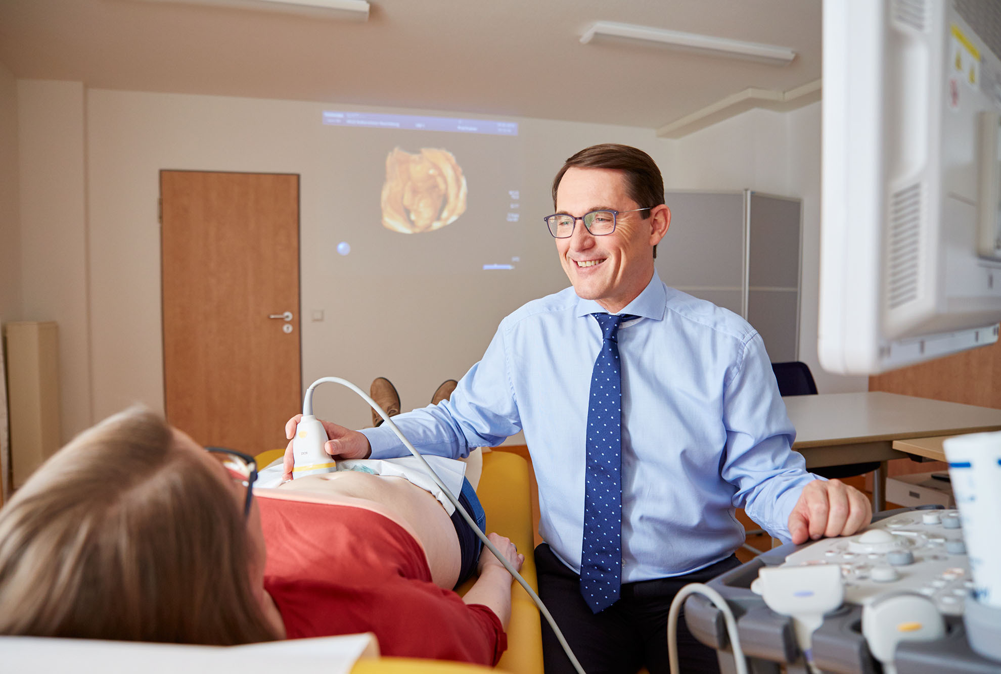 Chefarzt Prof. Dr. Franz Kainer untersucht im MVZ eine Patientin mit einem hochauflösenden Ultraschallgerät.