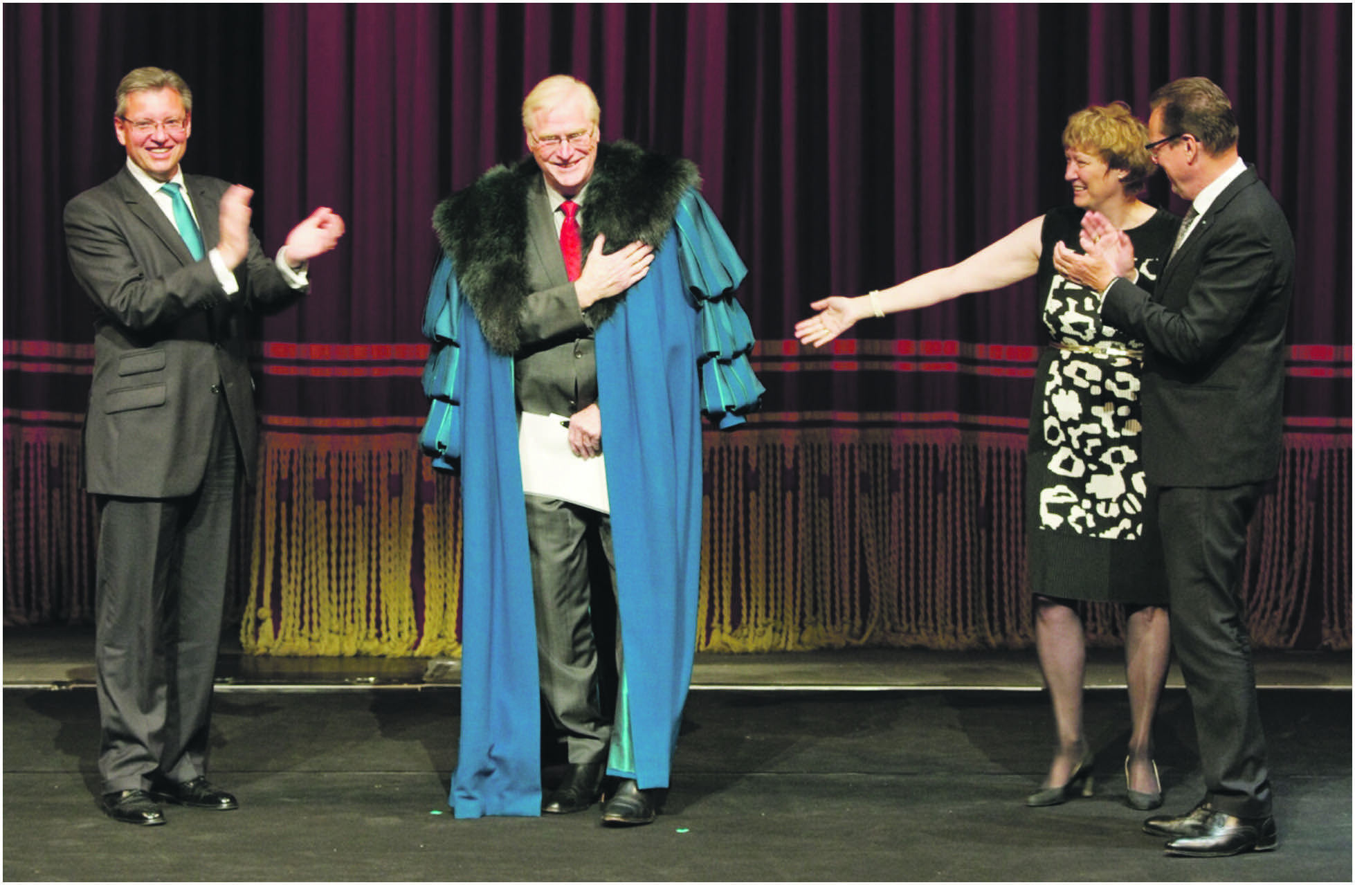 Dr. Roland Fleck, Präsident der Gesellschaft der Freunde der Staatsoper Nürnberg e.V., Kammersänger Heinz Klaus Ecker, Opernfreunde-Geschäftsführerin Ruth Beugel und Staatsintendant Peter Theiler bei der Ehrung Eckers mit einem Original-Mantel Veit Pogners aus Wagners „Die Meistersinger von Nürnberg“. Diesen türkisblauen Mantel trug Ecker vielfach und war sichtlich berührt und überrascht von diesem symbolträchtigen Präsent.