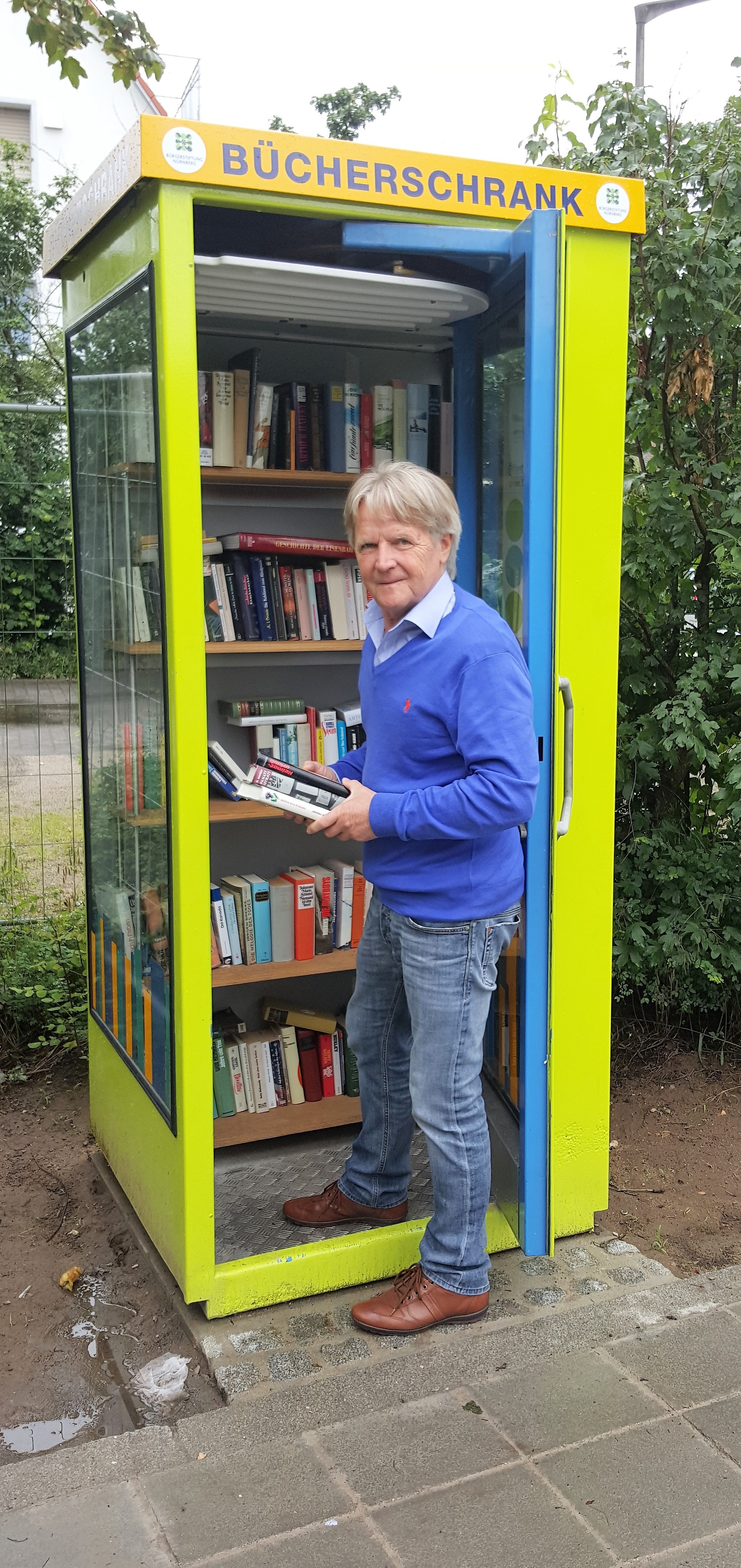 Helmut Hantke von der Bürgerstiftung Nürnberg beim Befüllen des neuen öffentlichen Bücherschranks am Leiblsteg.
