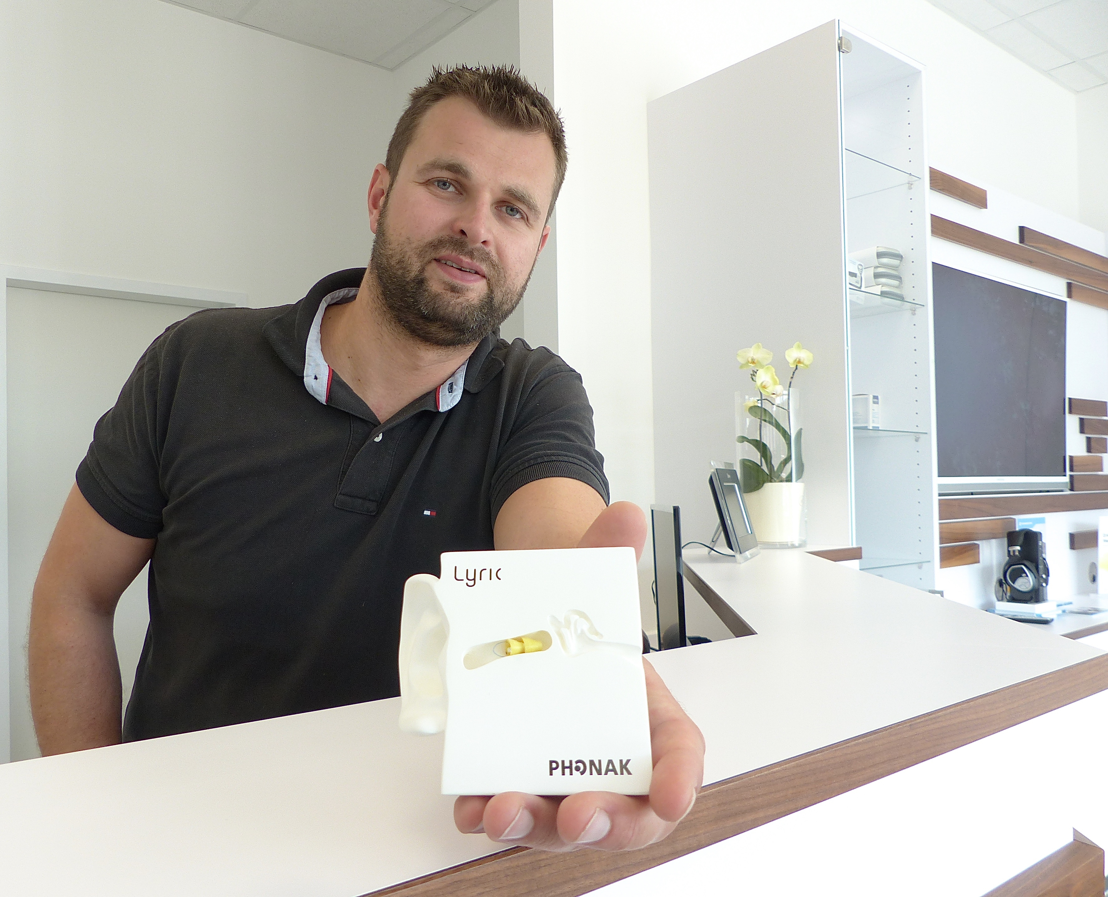 Benjamin Butscher mit dem „Lyric“-Hörgerät im Miniaturformat, das bis zu drei Monate im Gehörgang bleiben kann. Foto: Uwe Müller