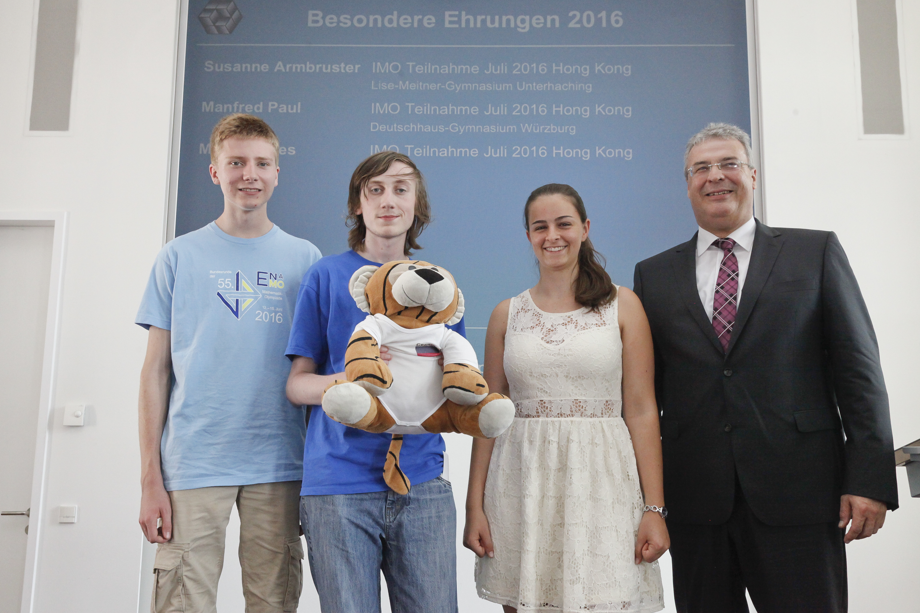 Die drei ehemaligen Landessieger Martin Drees, Manfred Paul und Susanne Armbruster (v.l.), Teil der deutschen Mannschaft für die Mathematik-Olympiade in Hongkong, zusammen mit dem NÜRNBERGER Vorstandsmitglied Walter Bockshecker.