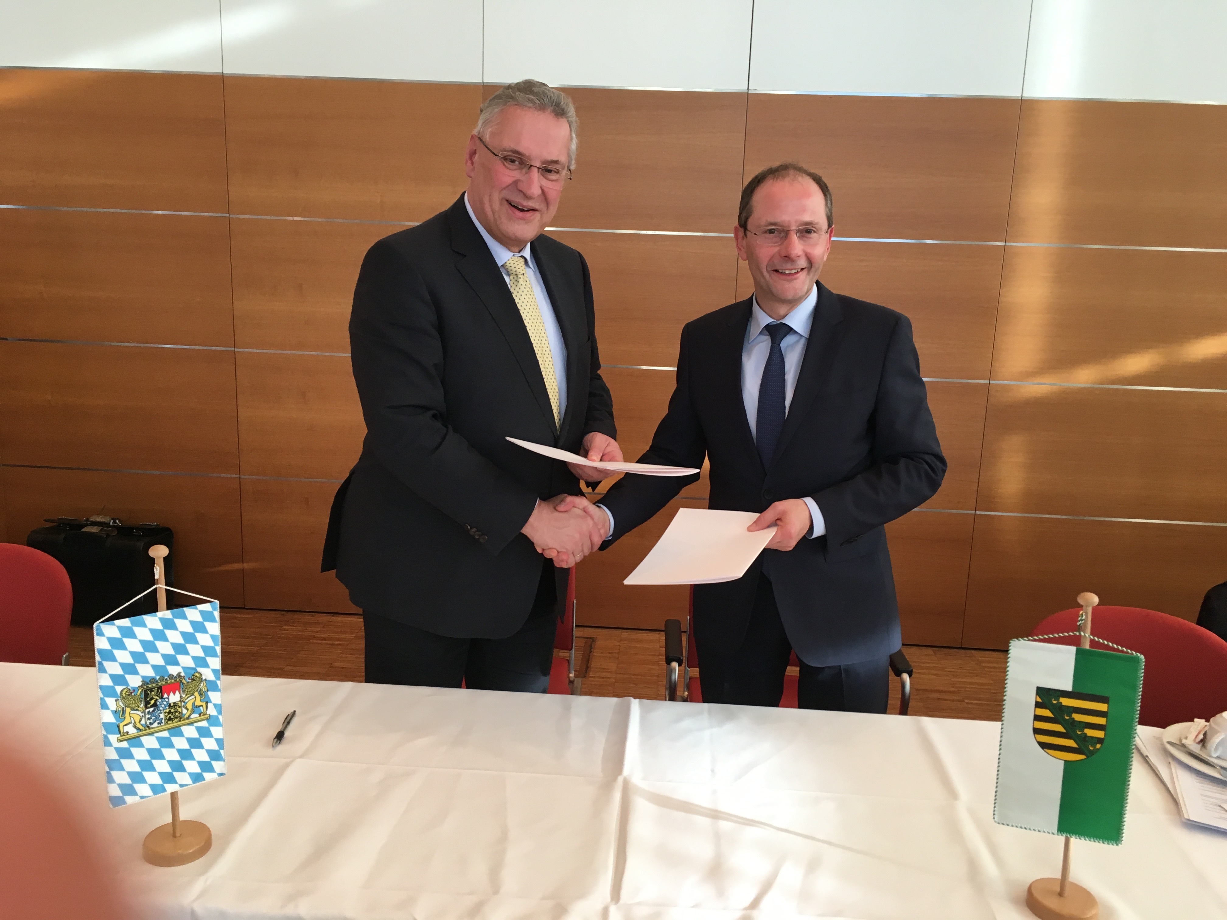 Bayerns Innenminister Joachim Herrmann (l.) und Sachsens Innenminister Markus Ulbig schließen Kooperationsvereinbarung mit 10-Punkte-Programm.