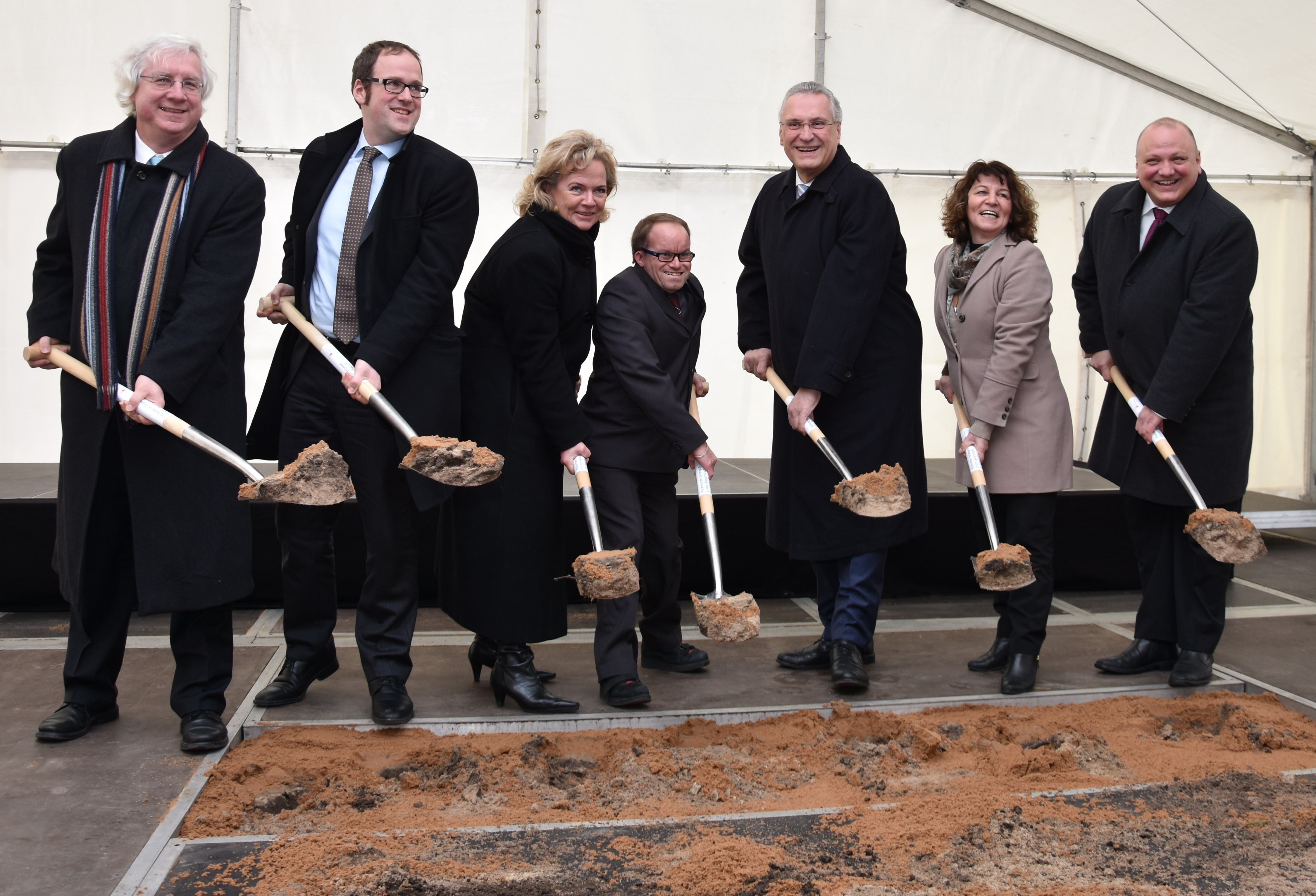 Unter dem Zeltdach griffen zum Spaten (v.l.) Dekan Peter Huschke, OB Dr. Florian Janik, die Landtagsabgeordnete Alexandra Hiersemann, Bewohner Johann Luthermoser, Innenminister Joachim Herrmann, die Bundestagsabgeordnete Martina Stamm-Fibich und Rektor Dr. Mathias Hartmann, Vorstandsvorsitzender der Diakonie Neuendettelsau, zum Spaten.