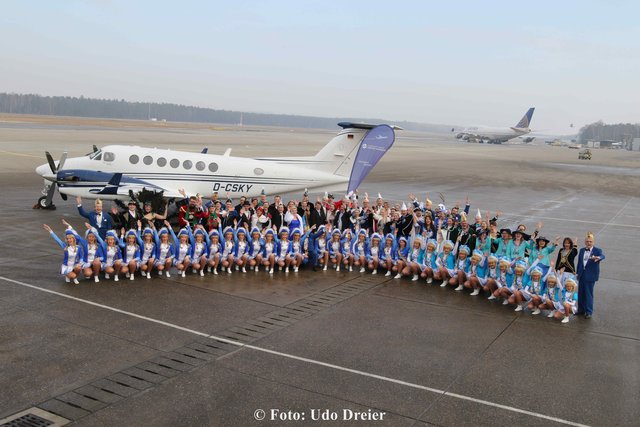 Gruppenbild der Prinzenpaare und Gardemädchen vor dem Flugzeug.