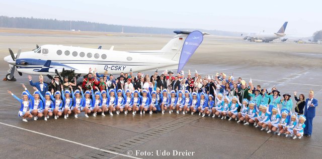 Gruppenbild Prinzenpaare und Gardemädchen vor dem Flugzeug.