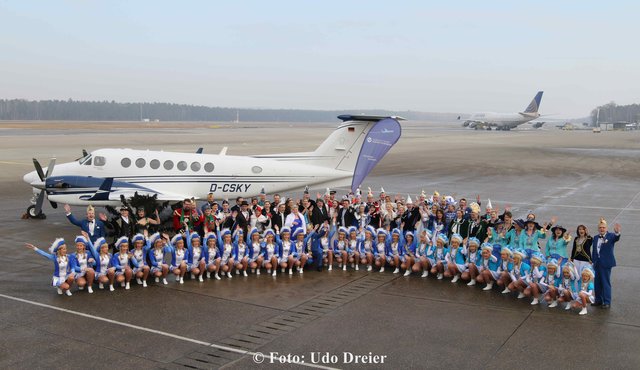 Gruppenbild Prinzenpaare und Gardemädchen vor dem Flugzeug.