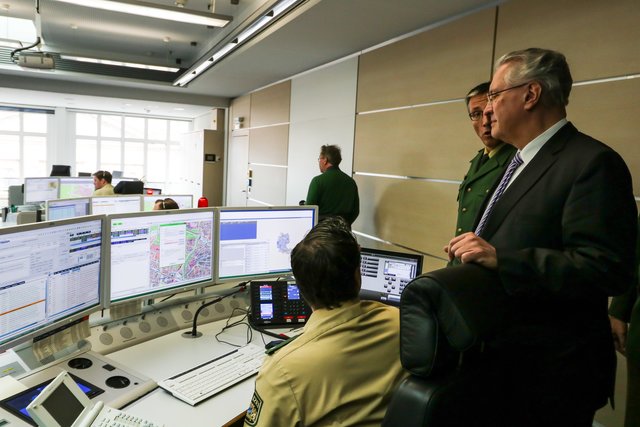 Der Bayerische Innenminister Joachim Herrmann (r.) lässt sich in der Einsatzzentrale in Nürnberg zeigen, wie das neue GPS-System in der Praxis funktioniert.