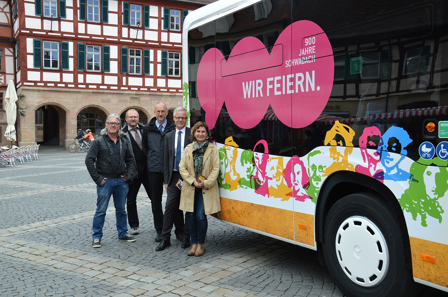 Grafik-Designer Bernd Klaus, Tobias Mayr (Betriebsleiter Stadtverkehr Schwabach), Winfried Klinger (Geschäftsführer Stadtwerke Schwabach), Umweltreferent Knut Engelbrecht und Sandra Hoffmann-Rivero (Projektleiterin Stadtjubiläum) stellen den Jubiläumsbus vor dem Rathaus symbolisch in Dienst.