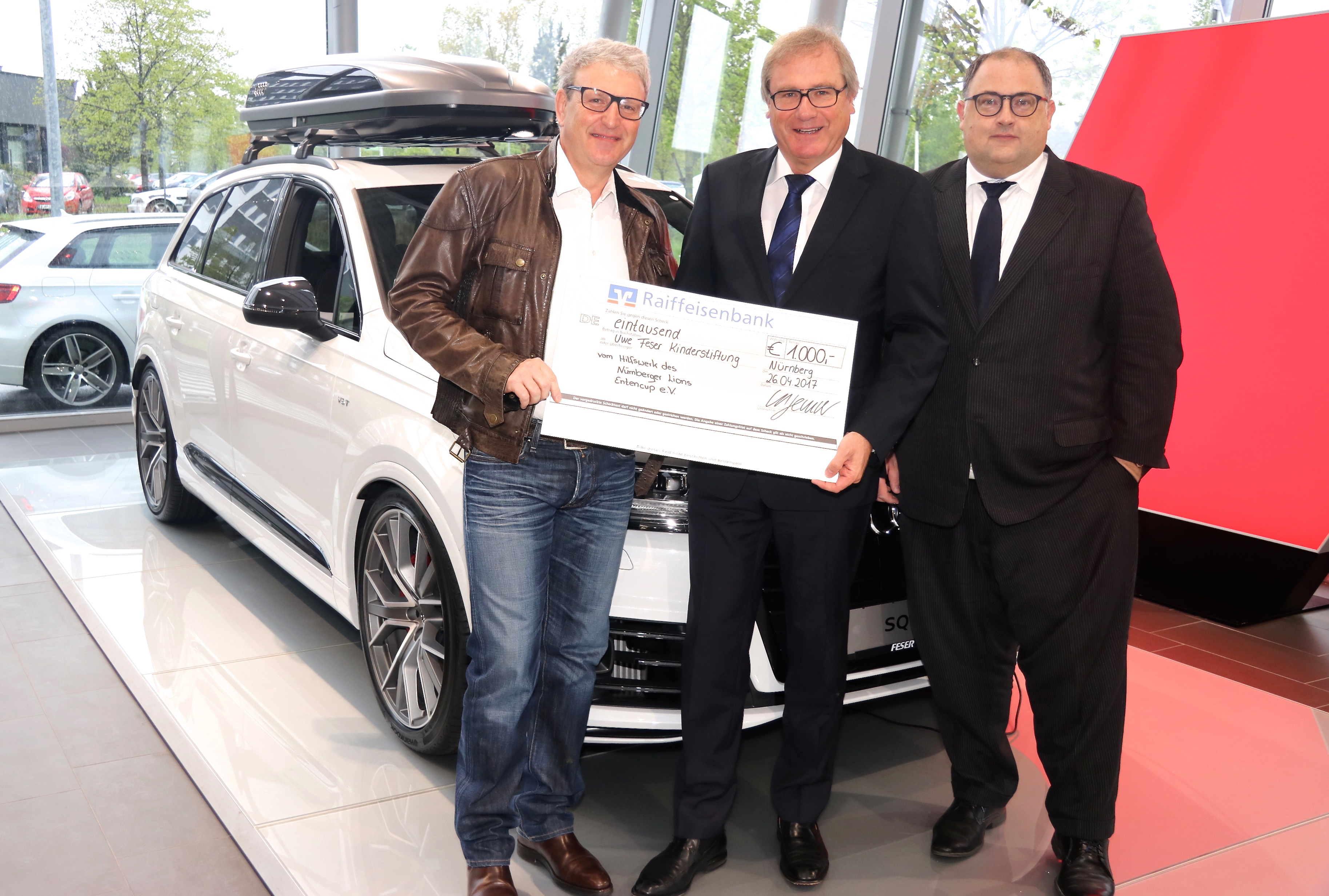 Dr. Michael Sauter (Lions Club / l.) übergab den Scheck an Uwe Feser (M.) zugunsten seiner Kinderstiftung. Mit dabei war auch Markus Rehm (Geschäftsführer Audi + VW Nürnberg-Marienberg). Foto: MStingl