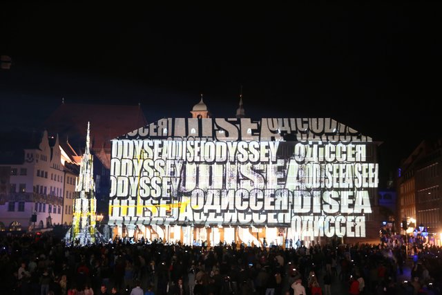Der Schriftzug "Odysee" in verschiedenen Sprachen auf der Fassade des Neuen Rathauses. Foto: © Udo Dreier