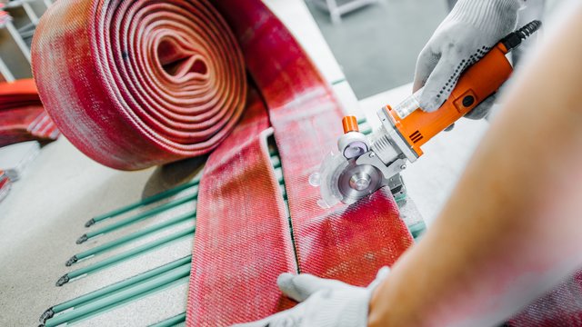 Aus den alten Feuerwehrschläuchen werden die Teile für den ,,neuen Einsatz" geschnitten. | Foto: Feuerwear Manufaktur