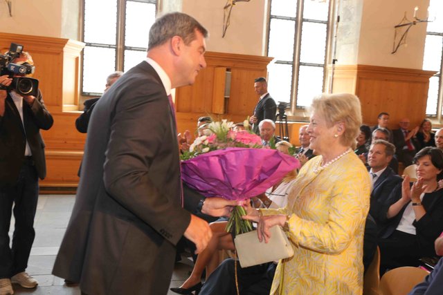 Finanzminister Dr. Markus Söder überreicht einen Blumenstrauß an Jossy Schneider. Foto: Udo Dreier