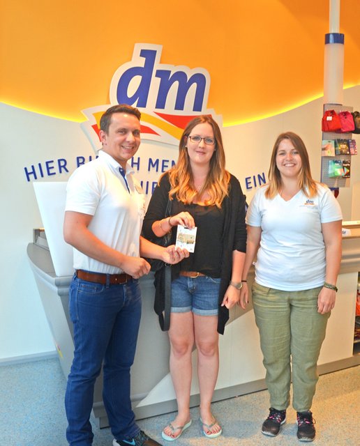 Kerstin Merstorf (M.) freut sich über ihren Einkaufsgutschein.