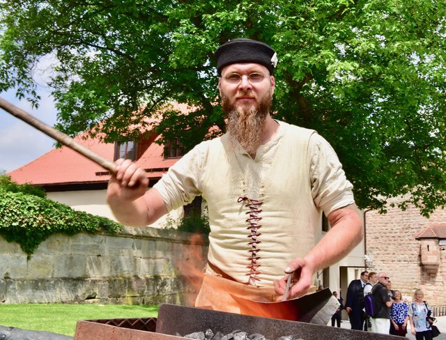 Der Burgschmied feuert seine Esse an. Foto: © Peter Maskow
