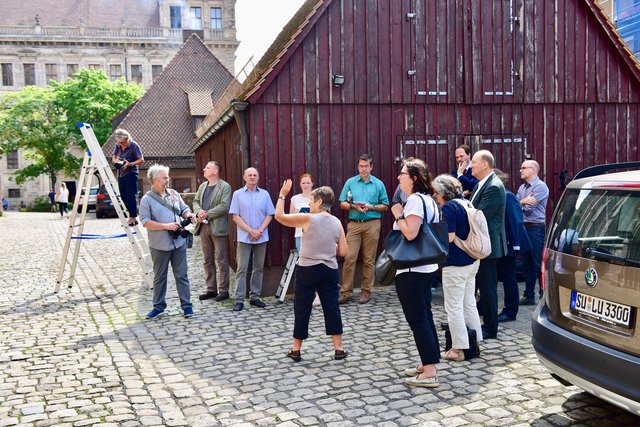 Architektin Andrea Fritsch﻿ erläutert die umfangreichen Arbeiten vor dem Südportal. Im Hintergrund das Bratwursthäusle und der Wolffsche Bau des Rathauses. Foto: © P. Maskow