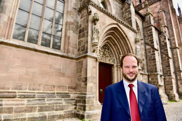 Pfarrer Jonas Schiller vor dem geretteten Weltgerichtsportal an seiner Kirche. Foto: © P. Maskow