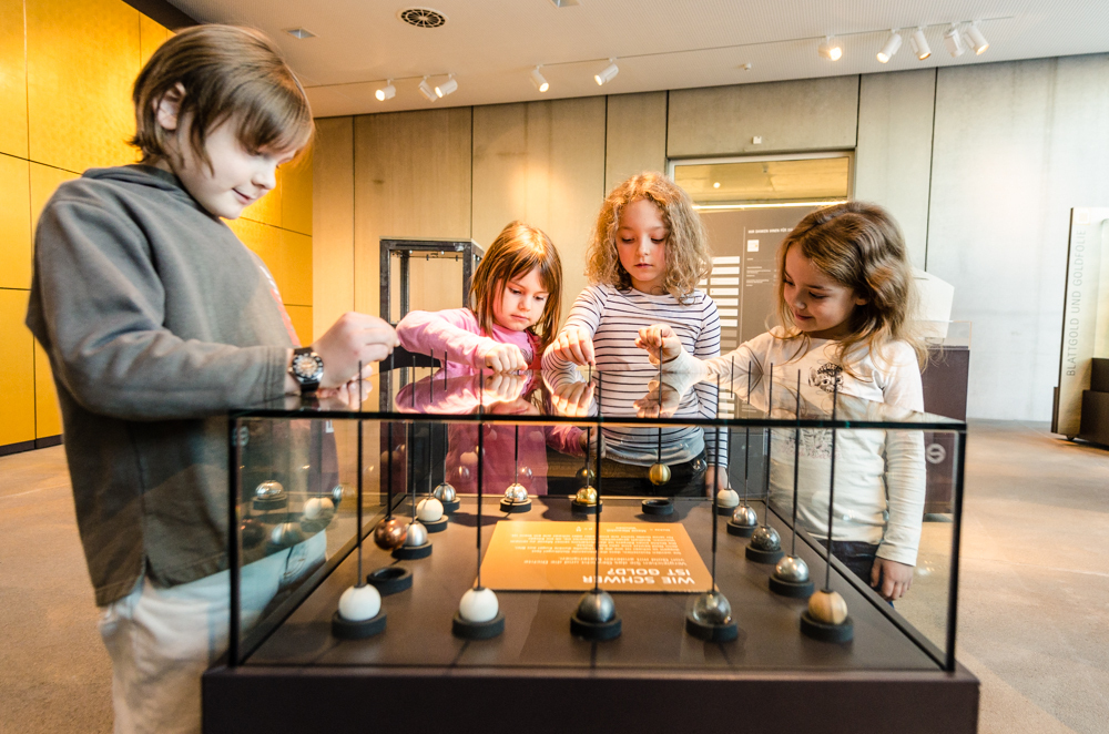 Kinder können am Ziehpult testen, wie schwer echtes Gold ist.
