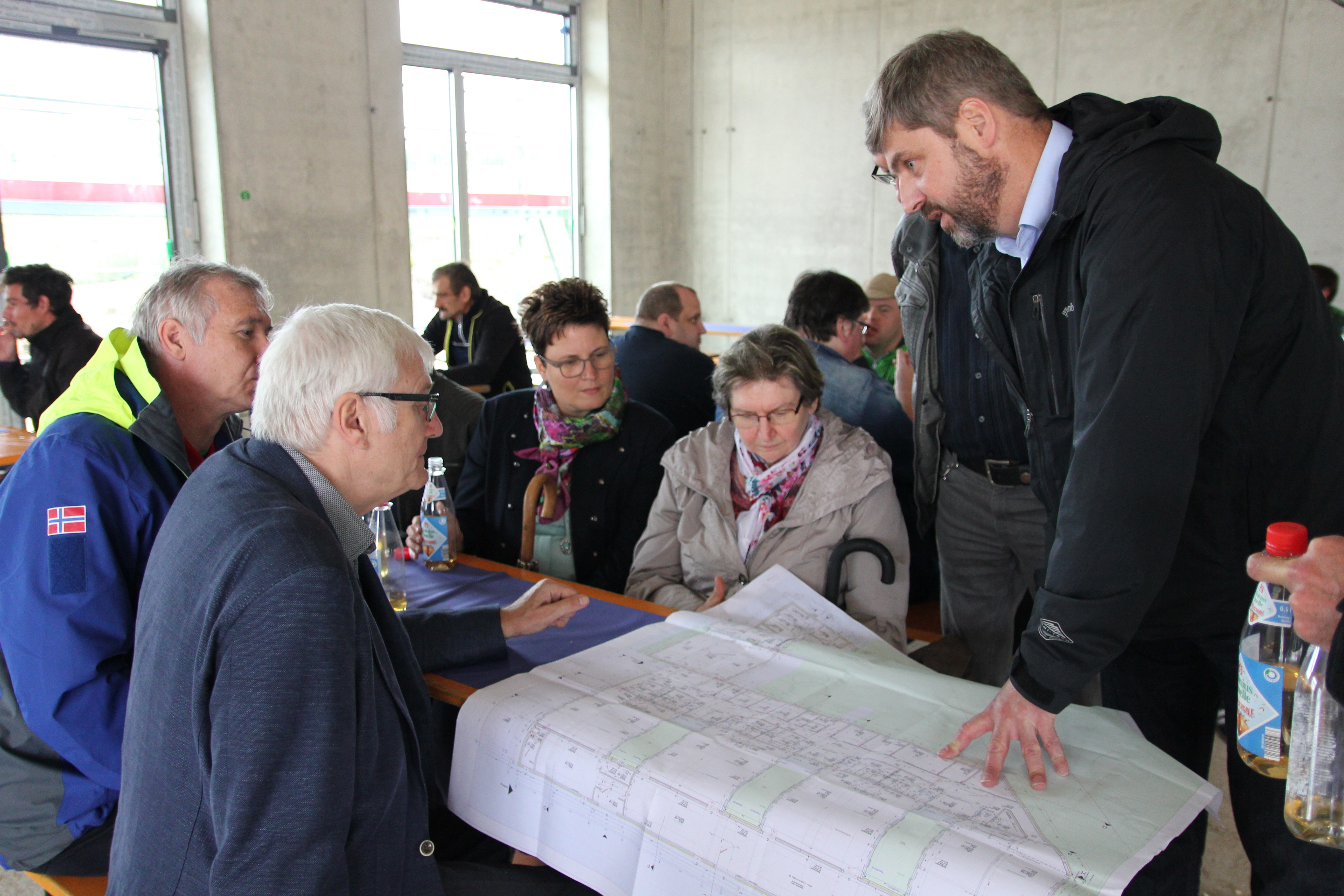 Der Geschäftsführer der Dambacher Lebenshilfe-Werkstätten, Rolf Bidner (re.) erläutert seinen Vorstandsmitgliedern anhand eines Bauplanes die einzelnen Abschnitte des Neubaus. Foto: Ebersberger