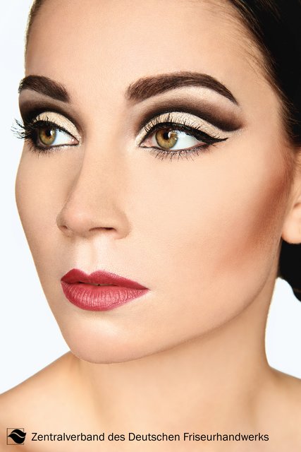 Für alle, die etwas mehr wollen: Der Kontrast zwischen aufregendem Schwarz und Gold bringt den Cut Crease auf das nächste Level. Die harte Grenze dieser beiden Farbwelten kreiert eine optische Täuschung und schafft dramatische Ausdrucksstärke. Mehr ist mehr, die Betonung liegt nicht nur auf den Augen, auch die Lippen werden bei diesem Look zum Hingucker. Hier erstrahlt ein sattes Rot und in Herbst und Winter in jedem Fall mit einem matten Finish. | Foto: Immo Fuchs, Köln / © Zentralverband Friseurhandwerk, Köln
