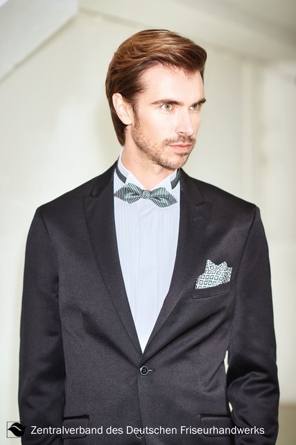 James Bond bei seiner neuesten Mission. Agentengleich wird bei diesem edlen Look für den Mann das Haar seitlich gescheitelt nach hinten geföhnt. Weg von der klassischen Tolle hin zum straighten Menstyle. Die Verwendung von Wax sorgt dabei für den strukturierten und eleganten Style. | Foto: Immo Fuchs, Köln / © Zentralverband Friseurhandwerk, Köln