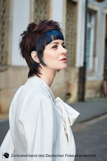 Exzessiv! Kombiniert mit einem eleganten Hosenanzug wird der Mullet in strukturierter, hinten aufgestellter Variante zum echten Statement. Die vordere Partie bleibt dabei glatt und präsentiert sich durch die verschiedenen Blau-Schattierungen auffallend shiny. So entfaltet der Denim-Jeans-Look hier seine ganz besondere Wirkung. | Foto: Immo Fuchs, Köln / © Zentralverband Friseurhandwerk, Köln
