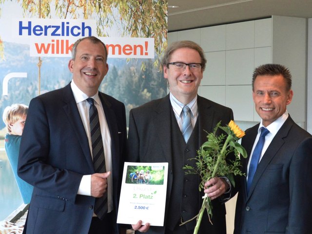 Stefan Schindler, Vorstandsvorsitzender der Sparda-Bank Nürnberg (l.), und Thomas Lang, stellvertretender Vorstandsvorsitzender der Sparda-Bank Nürnberg (r.), überreichen den Publikumspreis in Höhe von 2.500 Euro an das Markgräfin-Wilhelmine-Gymnasium in Bayreuth. | Foto: Sparda-Bank Nürnberg eG