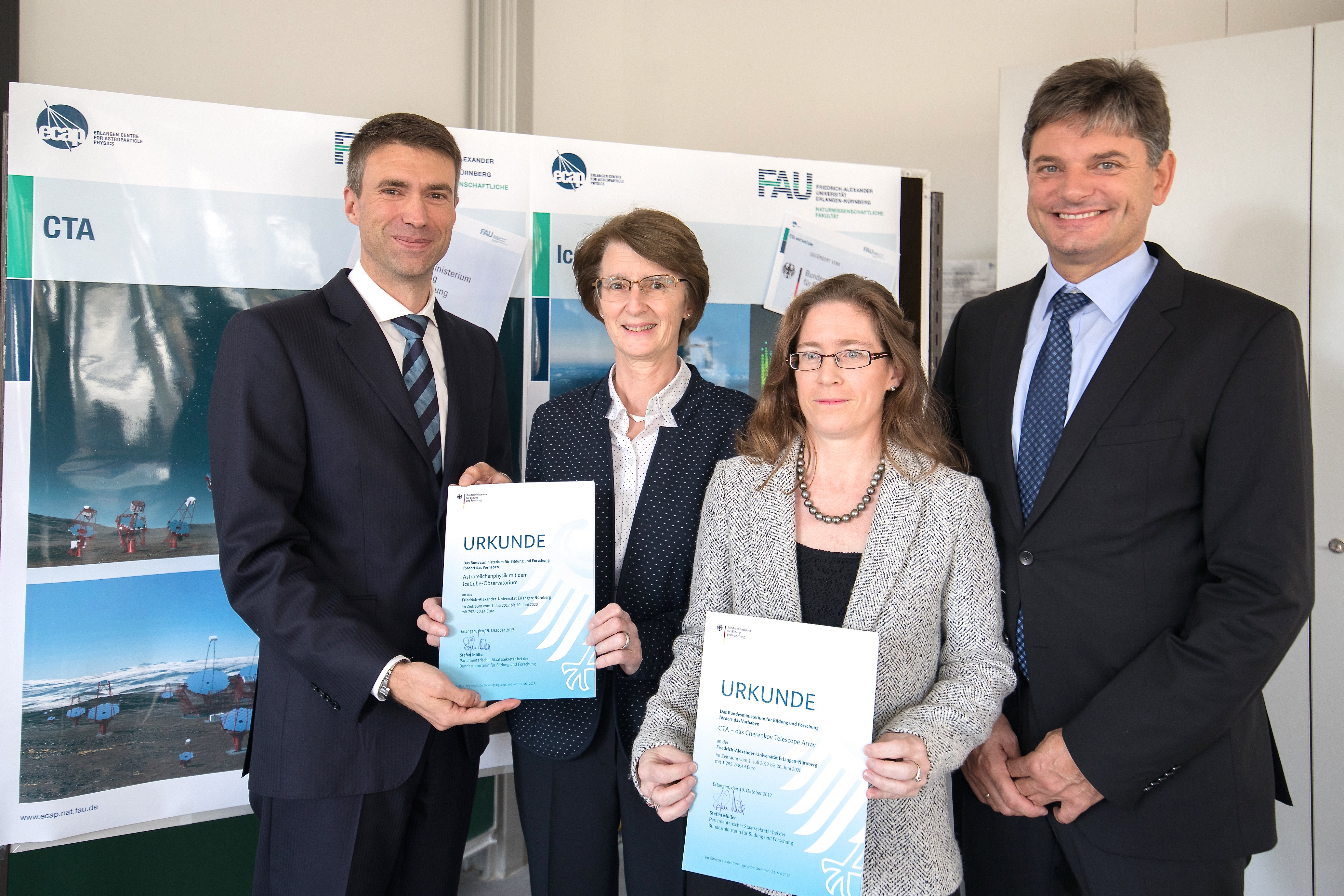 Förderbescheide über insgesamt 2,1 Millionen Euro übergab der Staatssekretär im Bundesforschungsministerium Stefan Müller (links) an Prof. Dr. Gisela Anton (2.v.l.) und PD Dr. Ira Jung-Richardt vom Erlangen Centre for Astroparticle Physics (ECAP) an der FAU im Beisein von Uni-Präsident Prof. Dr. Joachim Hornegger. Foto: FAU / Erich Malter