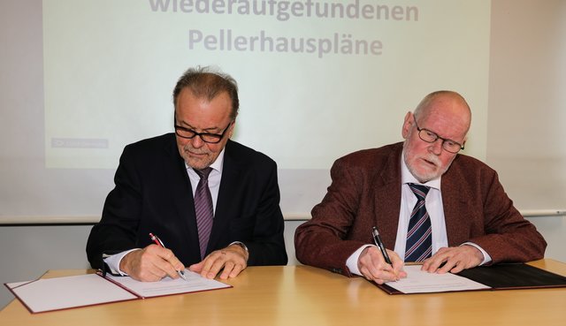 Karl-Heinz Enderle (l.), 1. Vorsitzender der Altstadtfreunde Nürnberg e.V., und Dr. Michael Diefenbacher, Leiter des Stadtarchivs Nürnberg, unterzeichnen die Schenkung der wiedergefundenen Pellerhauspläne. | Foto: Nicole Fuchsbauer