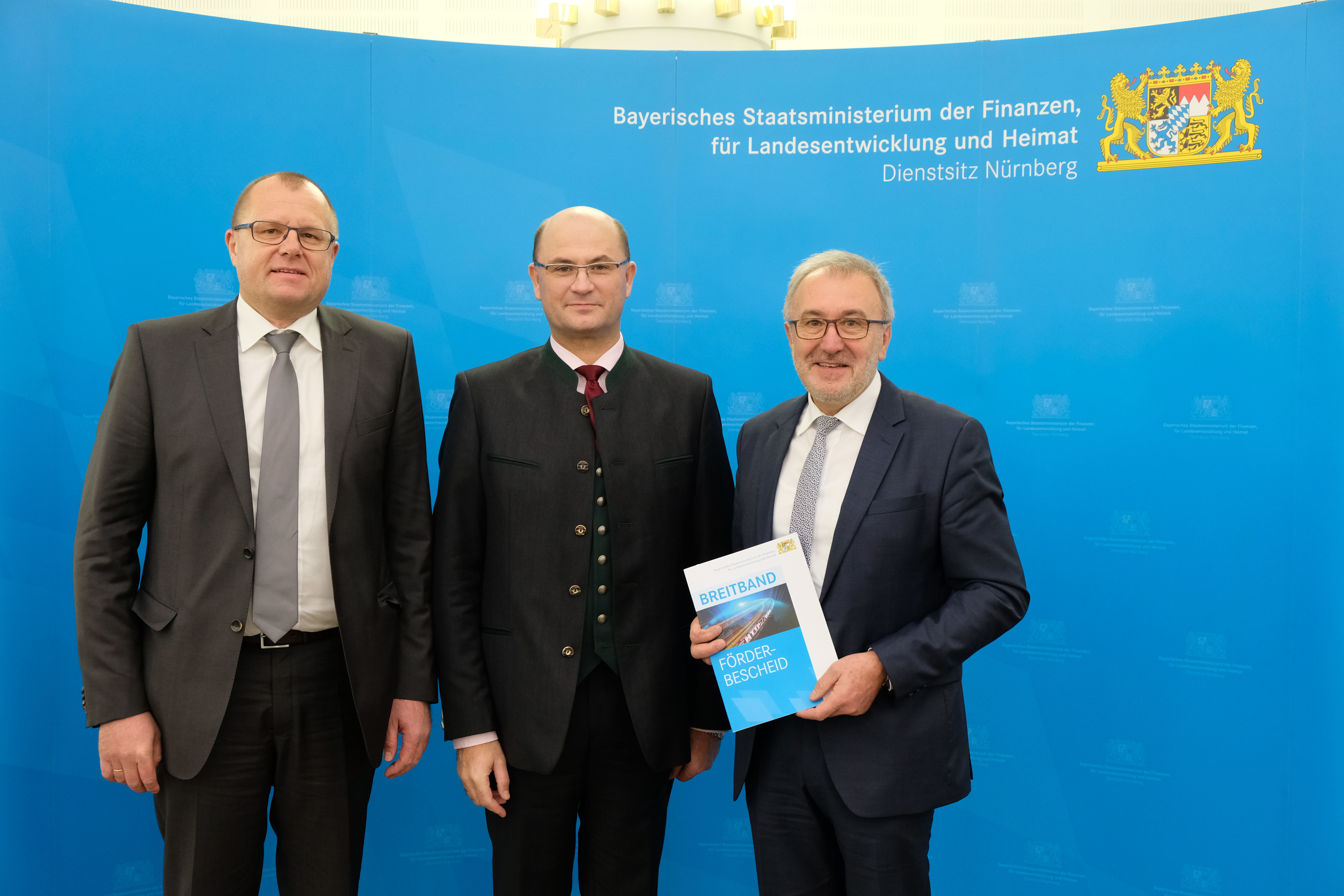 Finanz-Staatssektretär Albert Füracker (Mitte) übergibt den Förderbescheid an Bürgermeister Helmut Krämer (r.) und Geschäftsleiter Rüdiger Schmidt (l.).