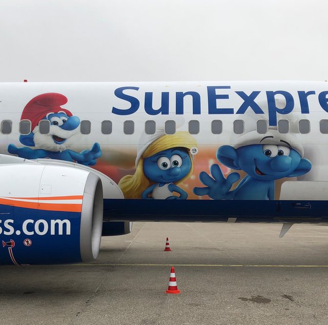 Ausgewählte Mitglieder der Schlumpf-Familie schmücken den Flugzeugrumpf.
