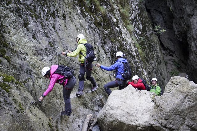 Lea (gelbe Jacke) muss sich über einen Klettersteig an einer Wand entlanghangeln. | Foto: © GERWIN, RTL