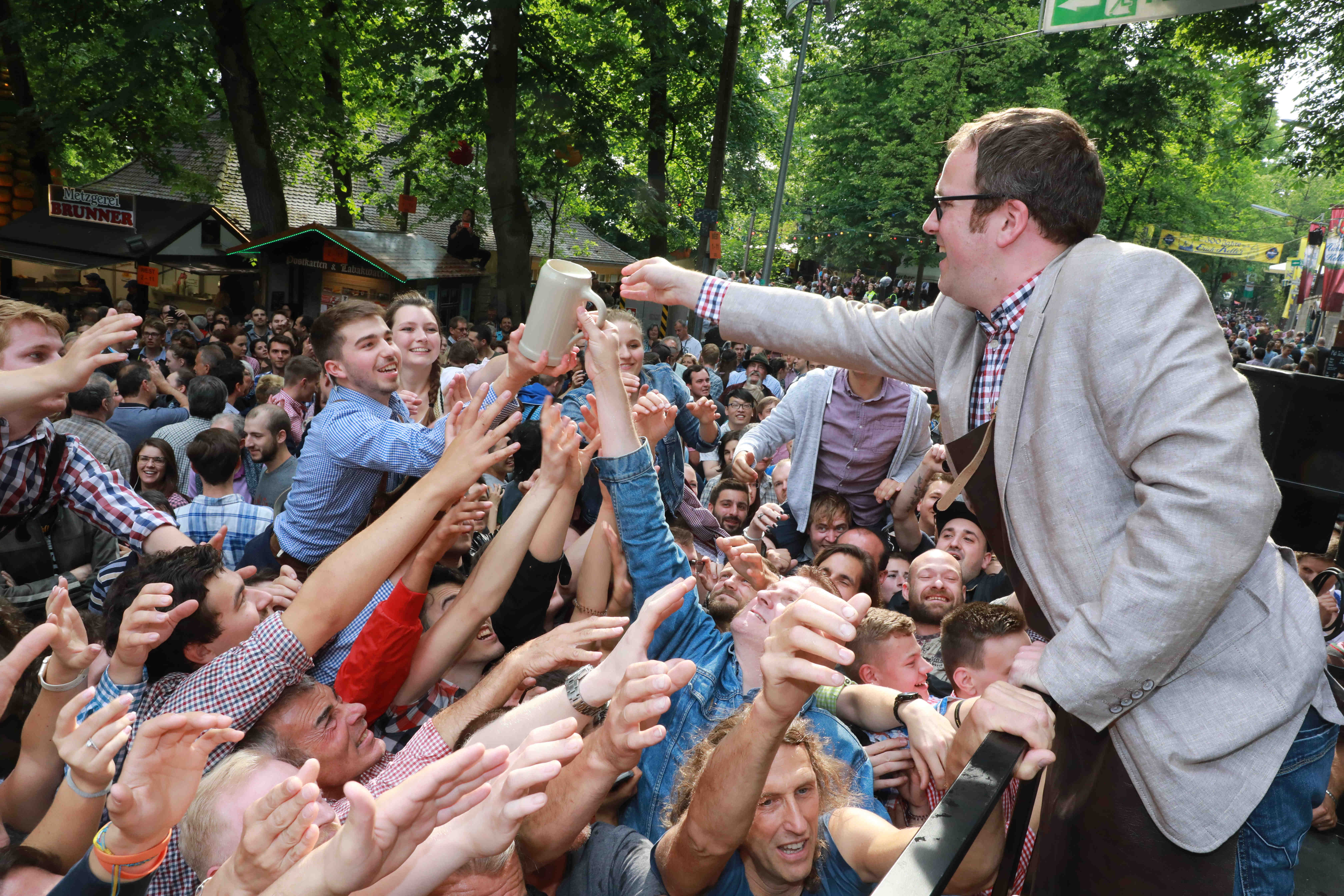 Und auf geht‘s! Das traditionelle Bild: OB Florian Janik reicht die ersten Krüge mit Freibier in die riesige Menge der Wartenden. Dutzende Hände versuchen, die Gratis-Maß zu ergreifen. Foto: Udo Dreier