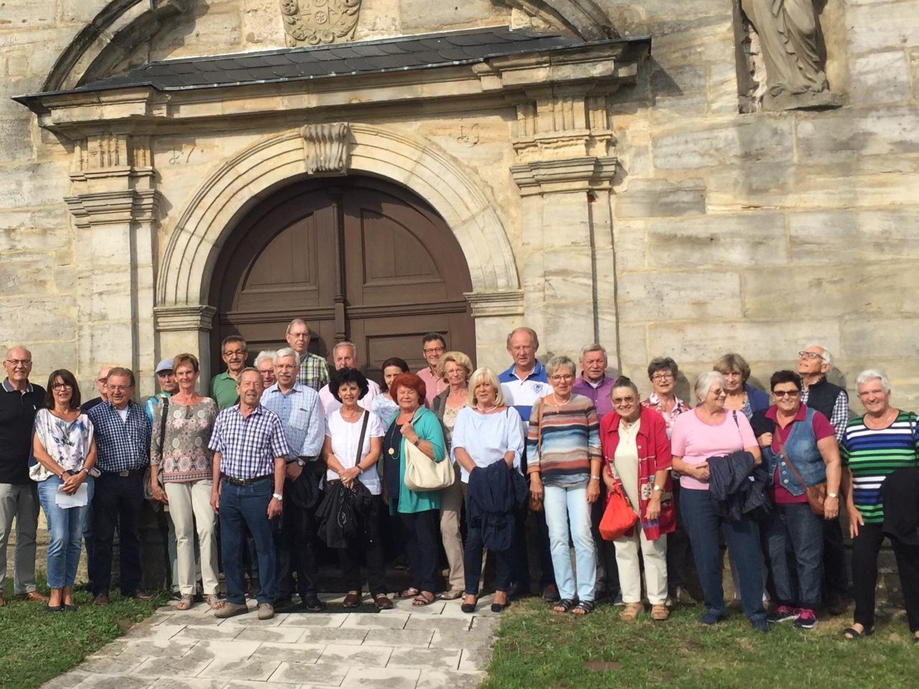 Mitglieder und Freunde des Männerkreises Don Bosco Forchheim vor der Barockkirche St. Johannes der Täufer in Schirnaidel.