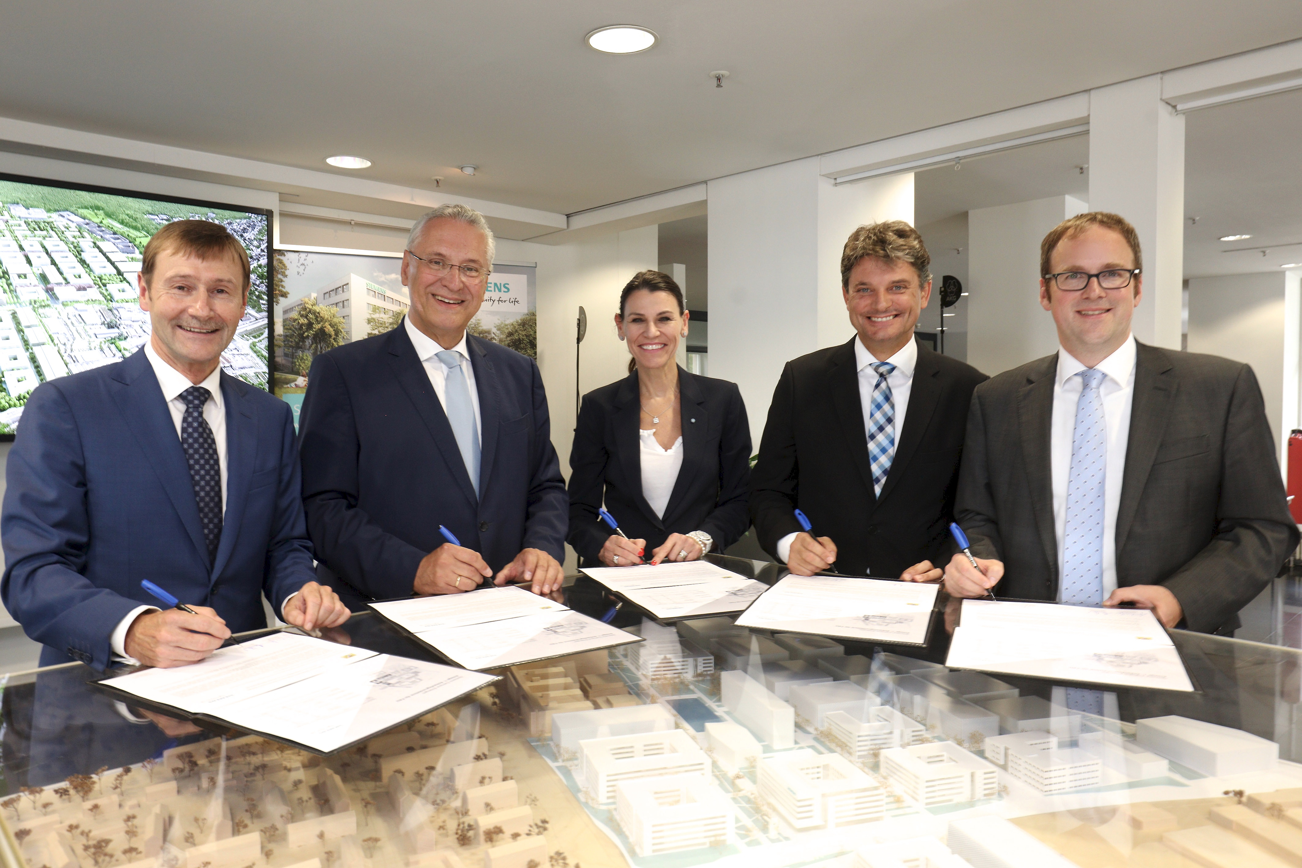 Offizielle Unterzeichnung der Rahmenvereinbarung für den Erwerb von SiemensCampus-Flächen für die FAU durch den Freistaat Bayern: Klaus Helmrich (Siemens-Vorstand), Joachim Herrmann (Bayerischer Staatsminister des Innern und für Integration), Prof. Dr. med. Marion Kiechle (Staatsministerin für Wissenschaft und Kunst), Prof. Dr. Joachim Hornegger (Präsident der Friedrich-Aexander-Universität) und Dr. Florian Janik (Oberbürgermeister Erlangen / v.l.n.r.). Foto: © Kurt Fuchs