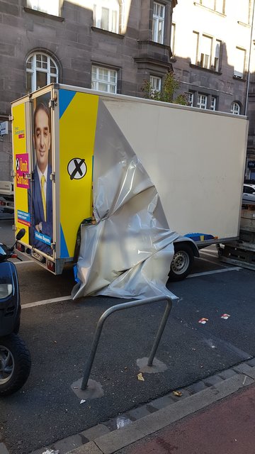 Kaputte Beklebung des Wahlkampf-Anhängers.