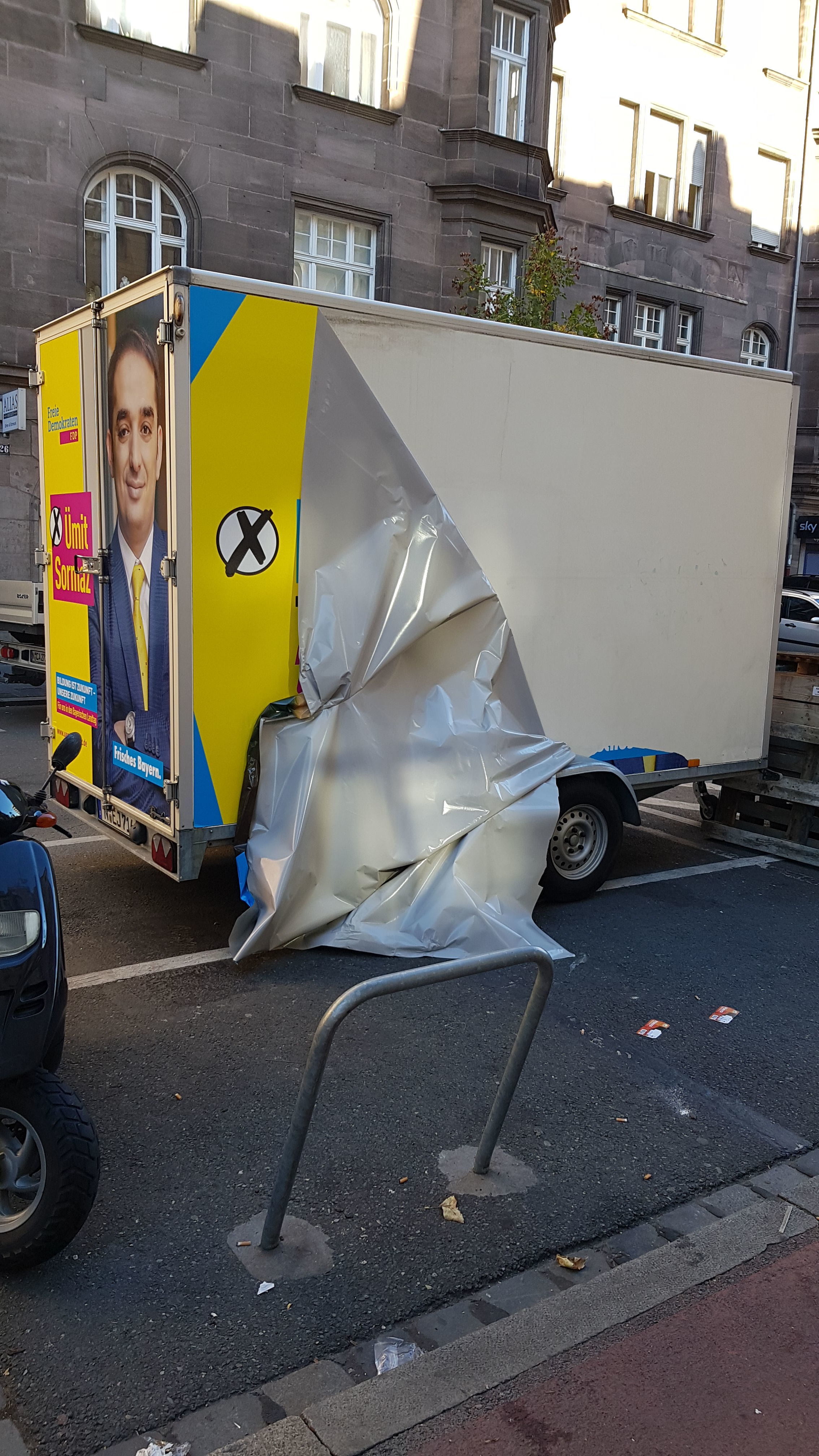 Kaputte Beklebung des Wahlkampf-Anhängers.
