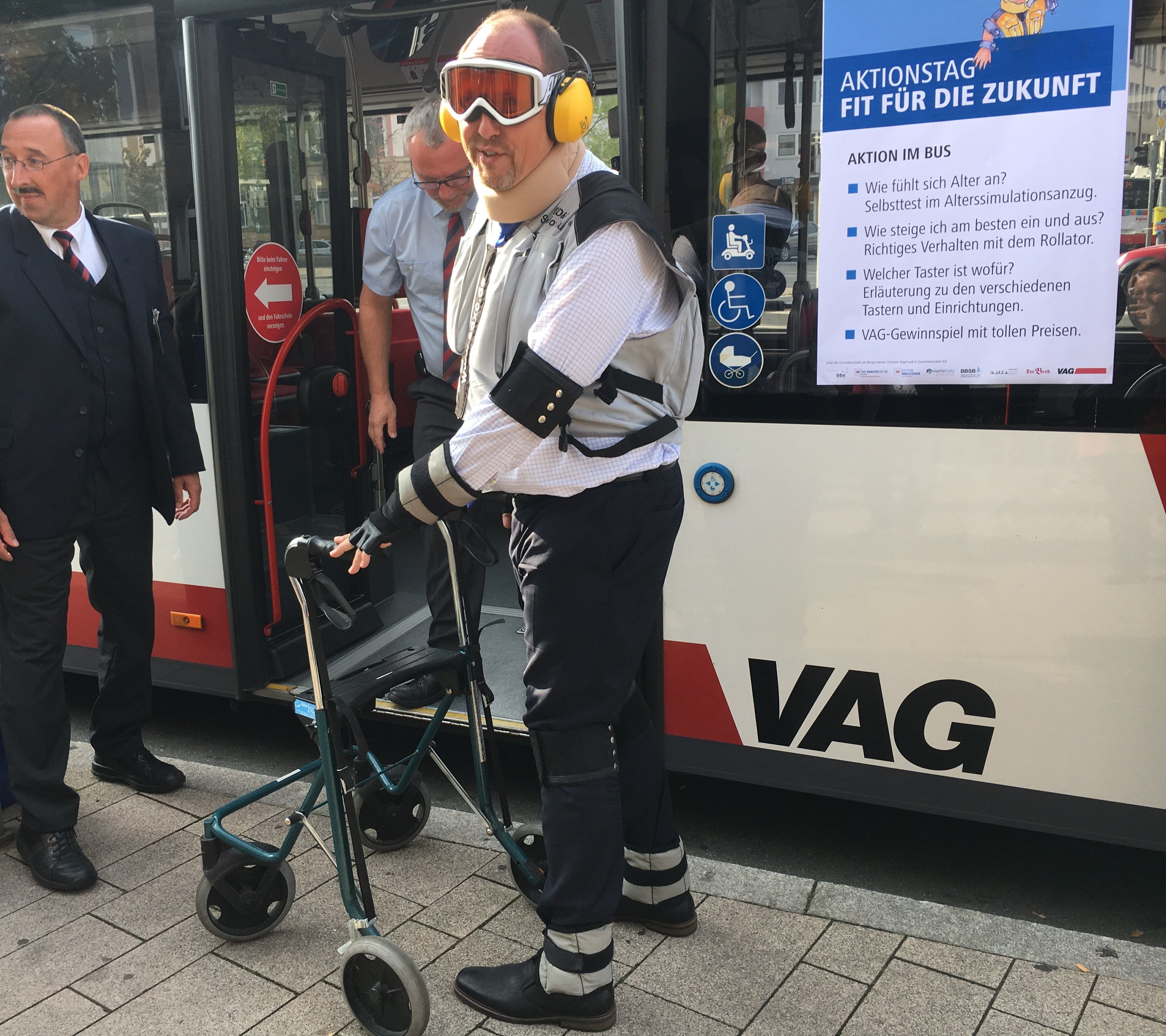 Bürgermeister und VAG-Aufsichtratsvorsitzenden Christian Vogel bei einem Rundgang durch den U3-Bahnhof Friedrich-Ebert-Platz mit eingeschränkter Sicht sowie beim Anprobieren des Alterssimulationsanzugs, den die VAG bei Schulungen ihres Fahrpersonals einsetzt.