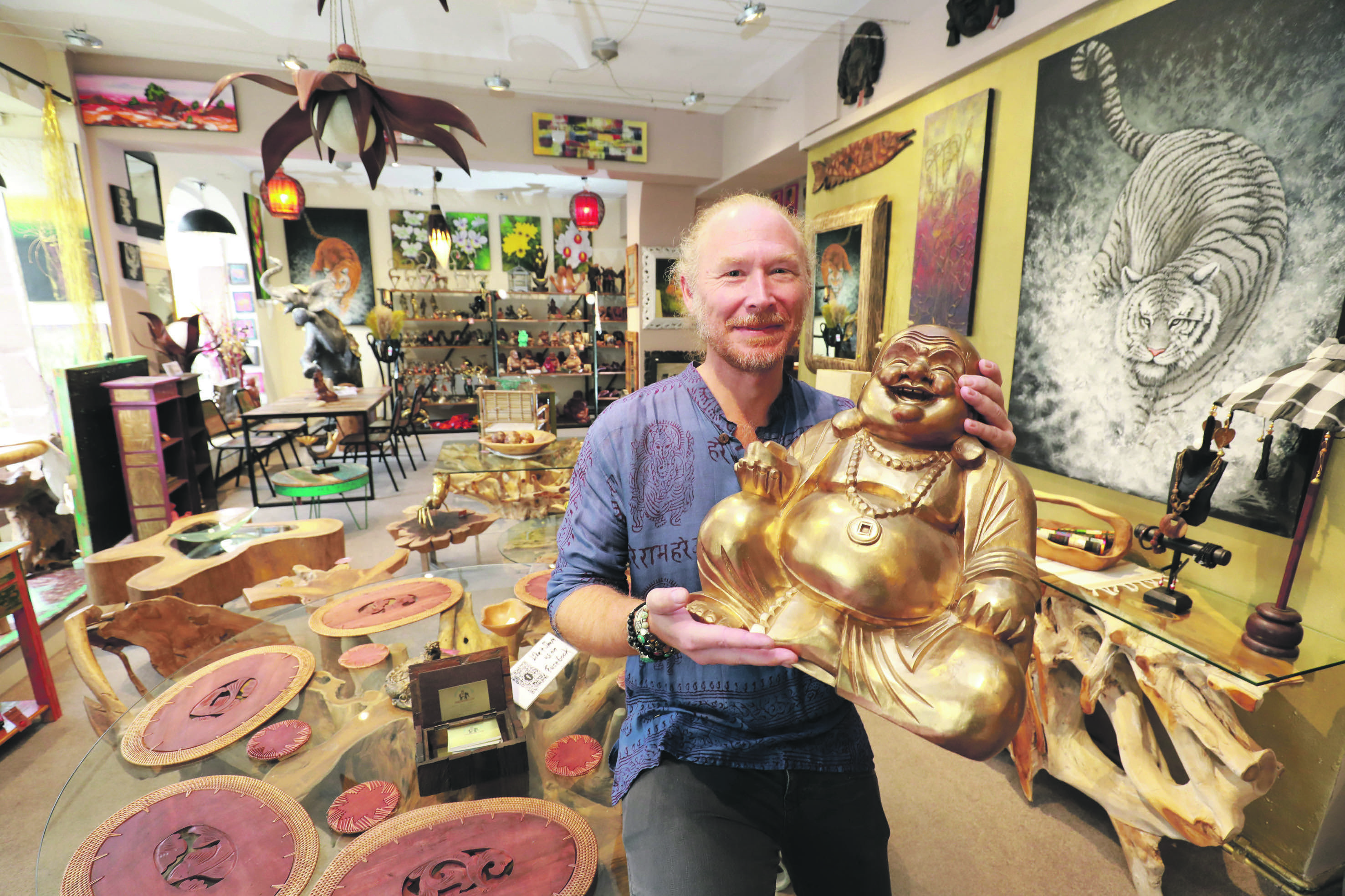 Bali-Experte Andreas Baumgarten in seinem neuen Laden mit einem prächtigen handgeschnitzten Buddha.