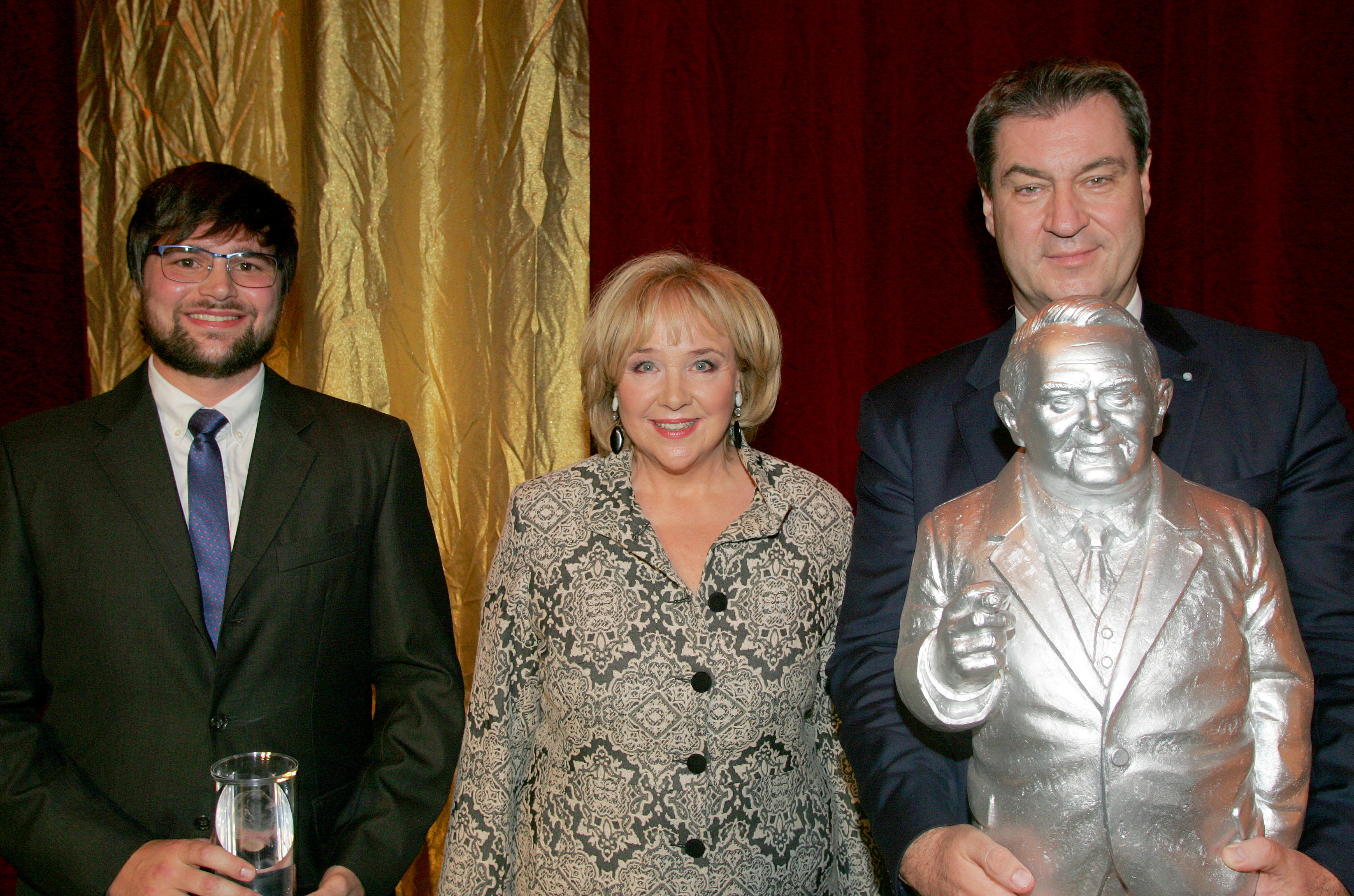 Ministerpräsident Dr. Markus Söder (r.), er bekam eine Ludwig Erhard-Figur geschenkt, der diesjährige Preisträger des Fürther Ludwig-Erhard-Preises, Dr. Florian Exler mit Evi Kurz, 1. Vorsitzende des Ludwig-Erhard-Initiativkreises Fürth.
