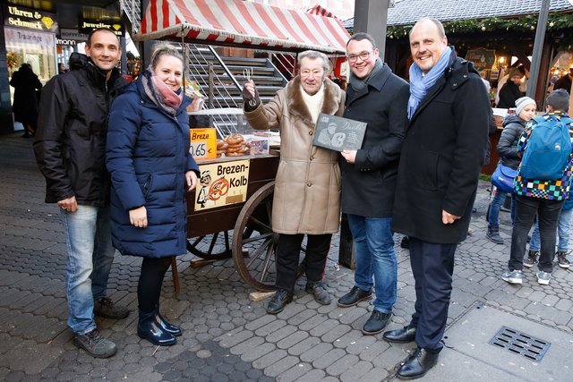 Gunter Seifert war 34 Jahre lang mit seinem mobilen Brezenwagen am Nürnberger Hauptmarkt für das Unternehmen Brezen Kolb tätig. Nun geht der 88-Jährige, der in ganz Nürnberg als der „Brezen-Mann“ bekannt ist, in den Ruhestand und wurde von den Geschäftsführern Jessica und Peter Kolb sowie dem 2. Bürgermeister Christian Vogel feierlich verabschiedet.