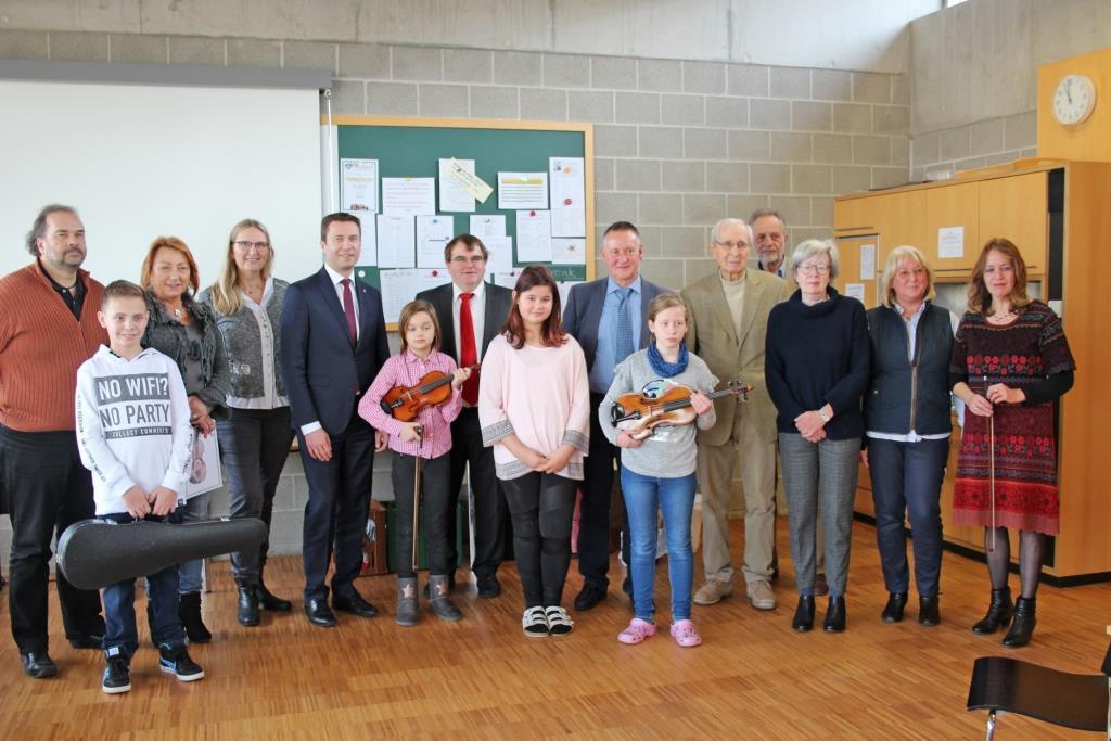 Mitglieder der drei Stiftungen: Manfred Bauer, Marianne Schwämmlein, Schulleiterin Ulrike Hambitzer, Landrat Matthias Dießl, Harry Scheuenstuhl, Lebenshilfe-Vorsitzender Dr. Thomas Jung, Hatto Bauer, Dr. Werner Rossmanith, Edith Elß, Irmtraud Bauer und Musikpädagogin Birgit Trunk mit Geigenschülern der Elisabeth Krauß Schule.