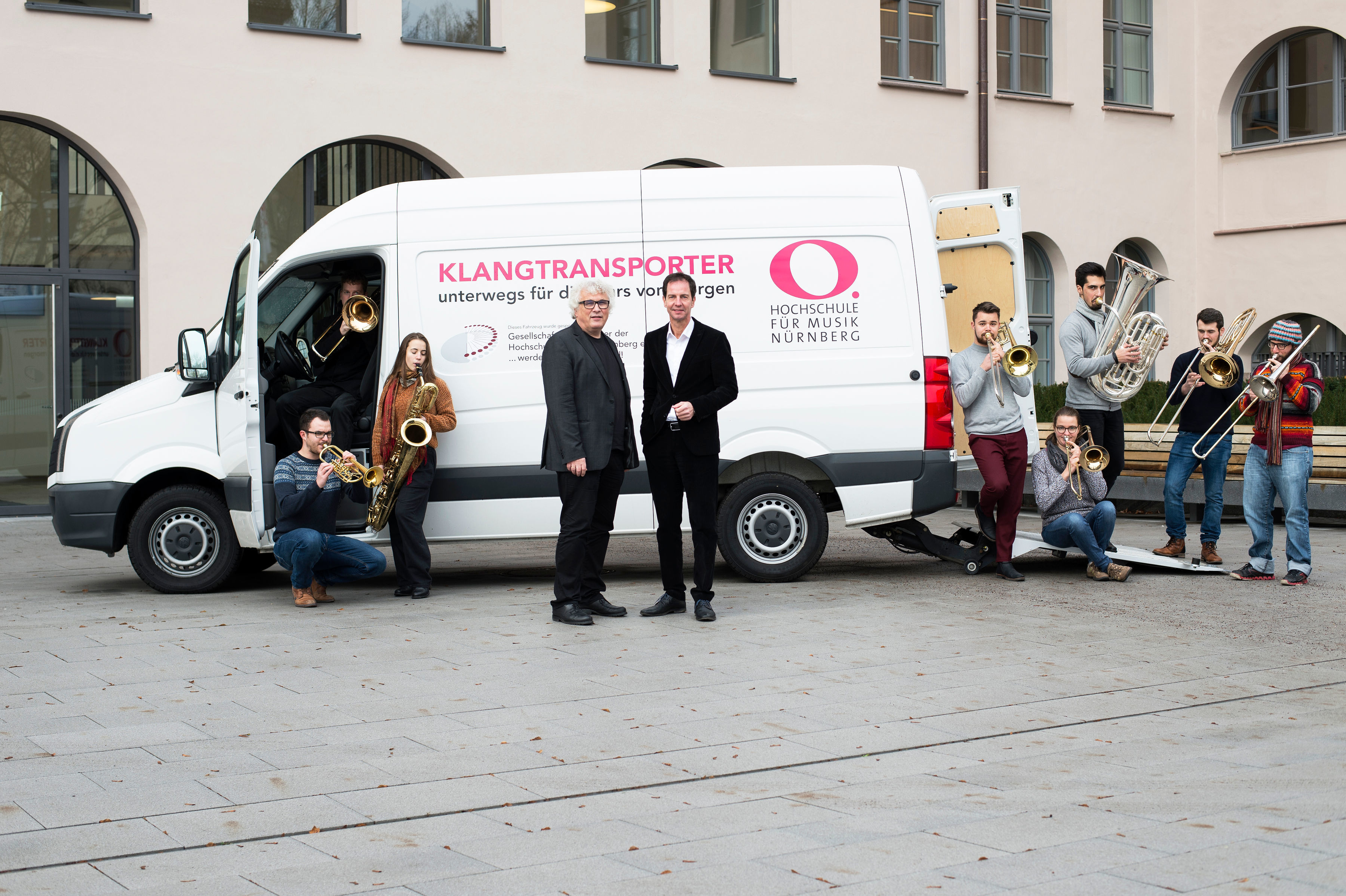Präsident Prof. Christoph Adt (l.) und Vorsitzender der Fördergesellschaft Lucius Hemmer (Intendant der Nürnberger Symphoniker) mit Studierenden vor dem neuen Transporter.
