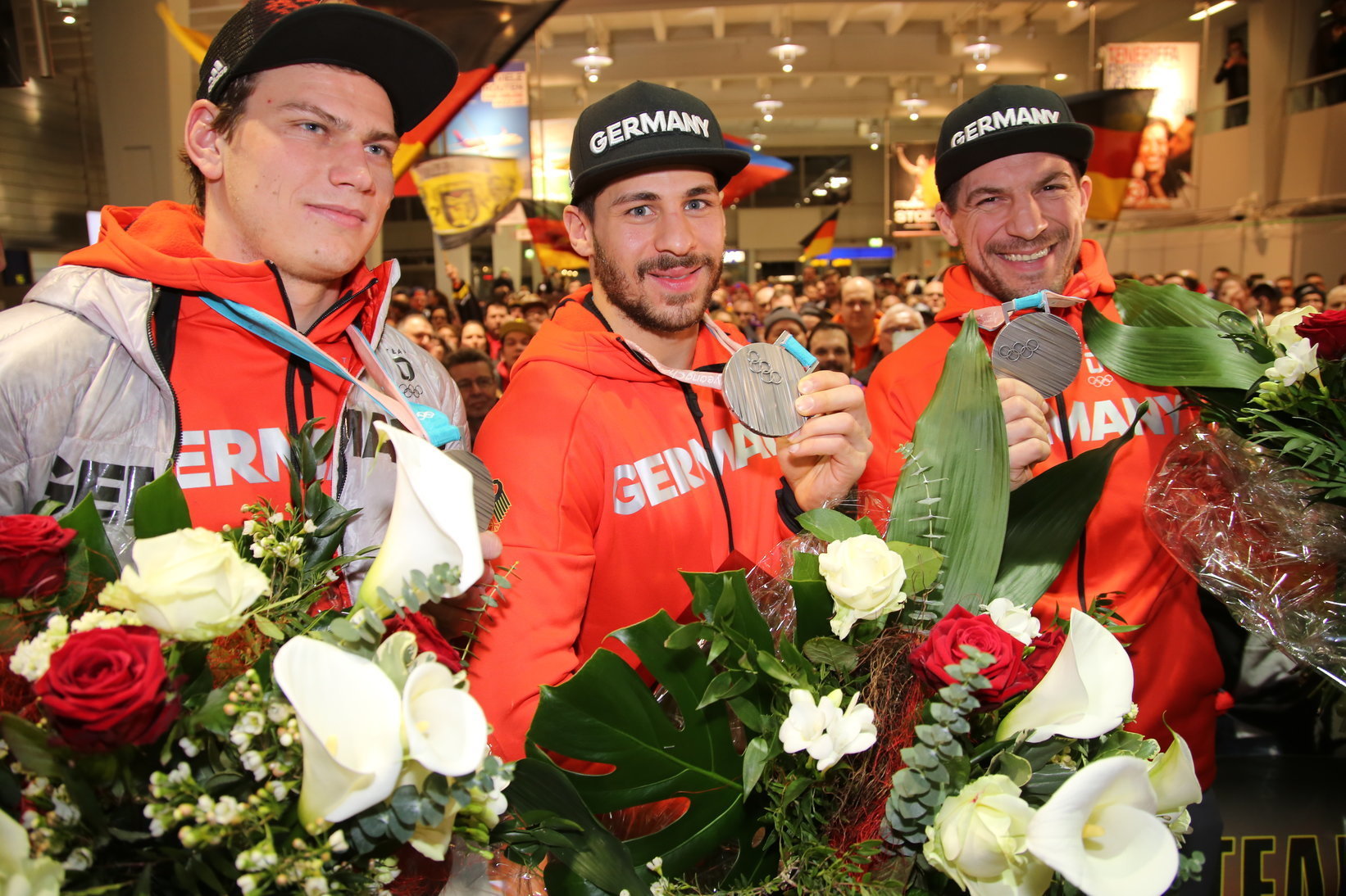 Leo Pföderl, Yasin Ehliz und Patrick Reimer zeigten im Februar 2018 ihre Silbermedaillen bei der Ankunft im Albrecht Dürer Airport Nürnberg.