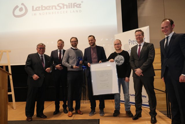 Die Brüder Matthias (3.v.l.) und Alexander Wexler (M.), EuWe Eugen Wexler GmbH &amp; Co. KG , wurden mit dem diesjährigen Lebenshilfe-Preis für Menschlichkeit ausgezeichnet.Gerhard John, Lebenshilfe Vorsitzender, Norbert Dünkel, Lebenshilfe Geschäftsführer, Betreutenvertreter Carin Winter und Laudator MAN-Werkleiter Dr. Ingo Essel sowie Dennis Kummarnitzky (v.l.), Stellvertretender Geschäftsführer Lebenshilfe,  gratulieren. | Foto: John R. Braun
