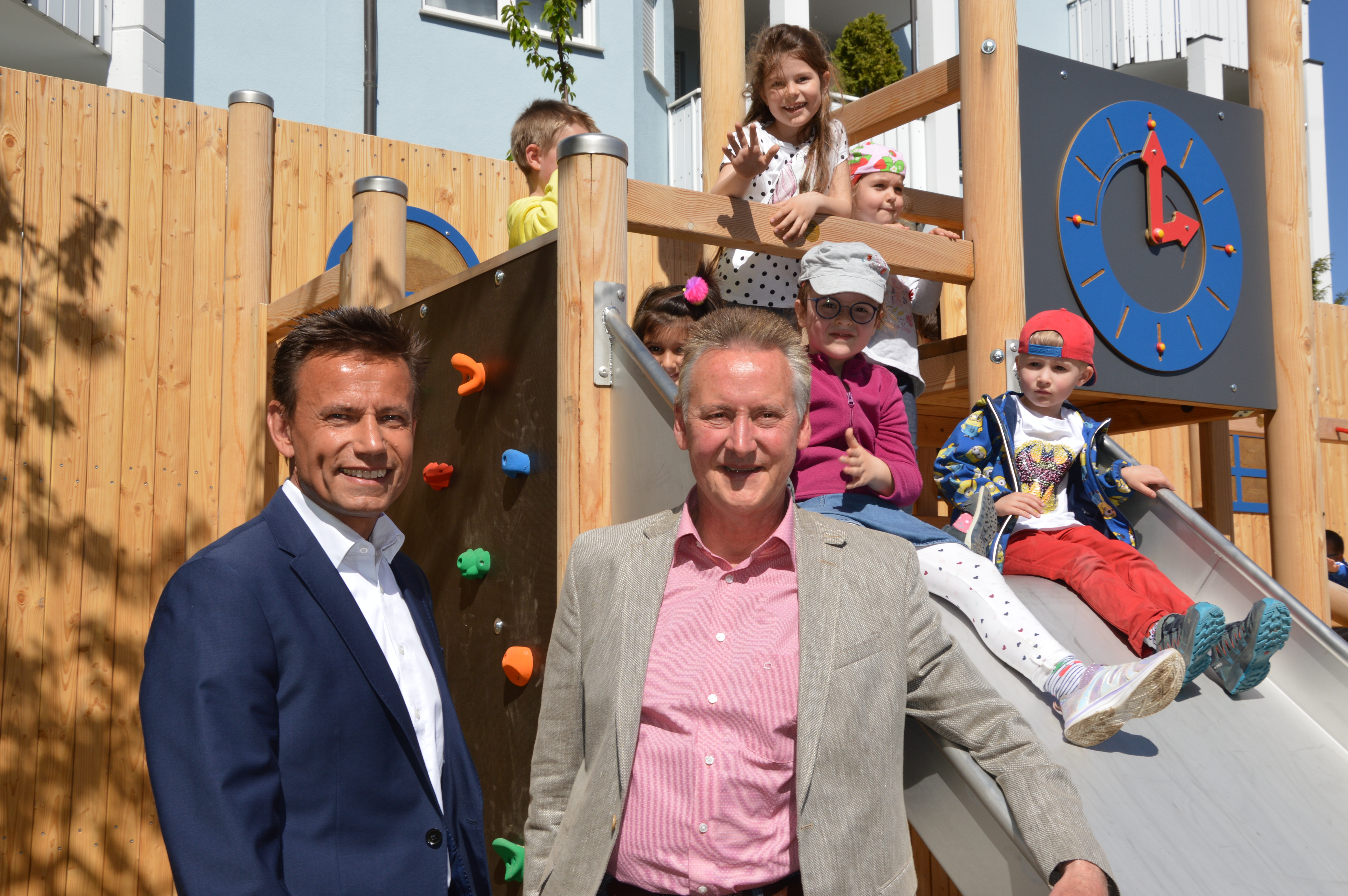 Dr. Thomas Jung (rechts), Oberbürgermeister der Stadt Fürth und Thomas Lang, stellv. Vorstandsvorsitzender der Sparda-Bank Nürnberg eG mit Kindern des nahegelegenen Kindergartens St. Paul.
