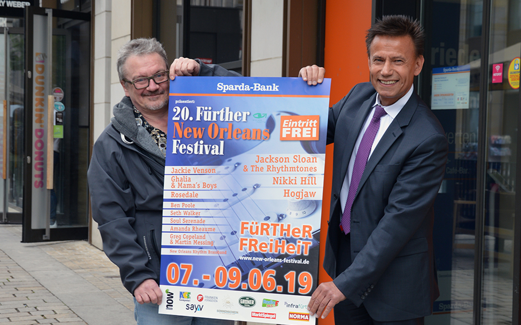 Thomas Lang, Stellvertretender Vorstandsvorsitzender der Sparda-Bank Nürnberg (r.), und Thomas Schier, Geschäftsführer des Stadtmarketingvereins Vision Fürth e. V. (l.) präsntieren das Plakat zum, New Orleans Festival.