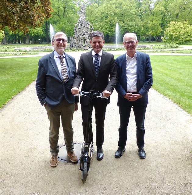 Als 2. Preis gibt‘s einen „Metz Moover“ – hier symbolisch durch Unternehmer Wilhelm Daum (l.) im Beisein von Siegfried Balleis (Vorsitzender Uni-Bund / r.) an Joachim Hornegger überreicht.
Foto: © Uwe Müller