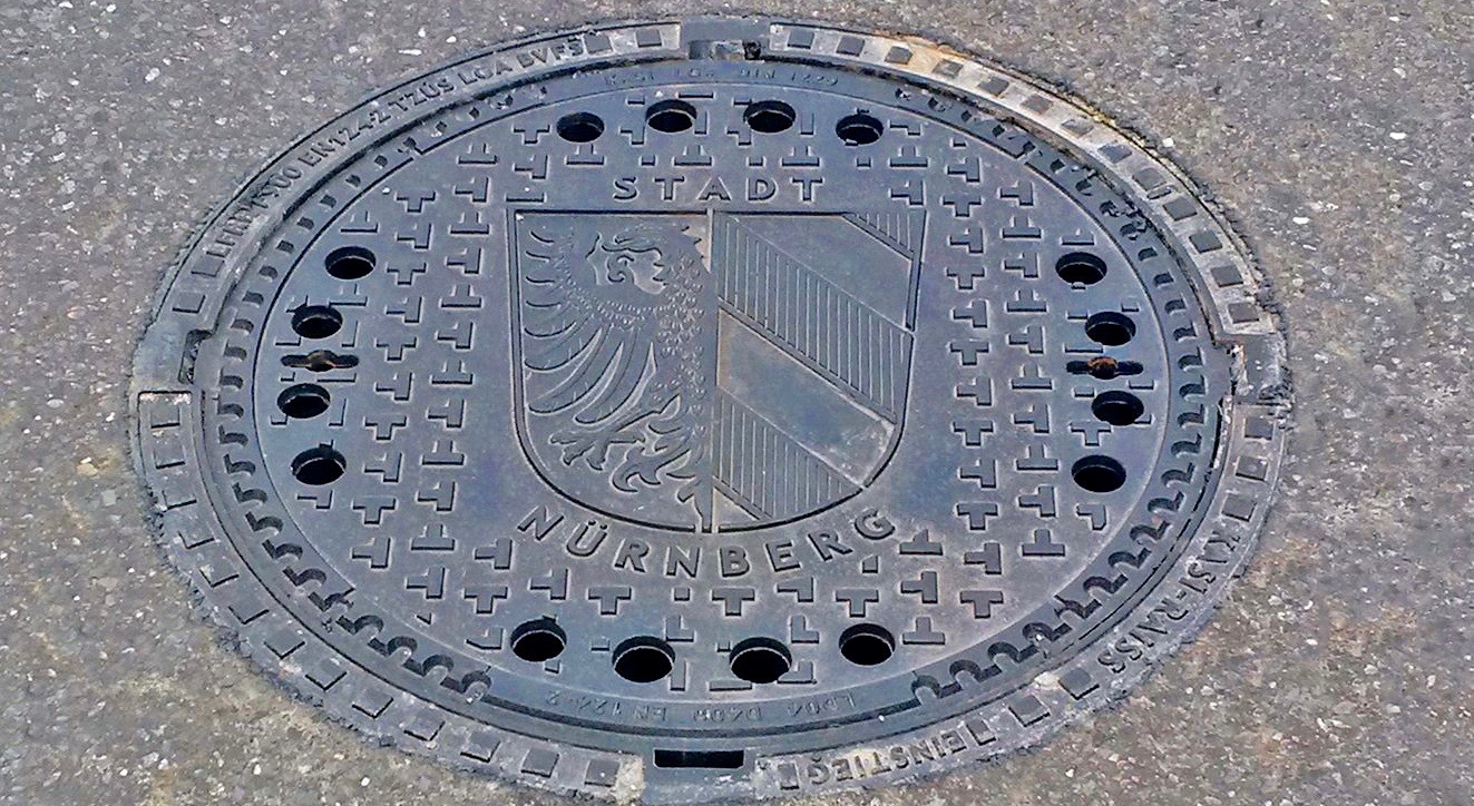 Erster Kanaldeckel mit Stadtwappen in der Färberstraße vor Hausnummer 31.