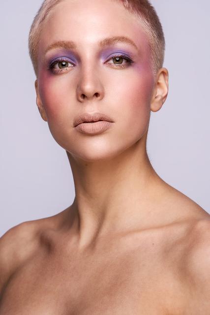 Der klassische rosa Blush feiert diese Saison sein Comeback. Das pudrig rauchige Pink-Rosé wird bis hin zu den Schläfen gesetzt und betont dabei gekonnt die Wangenknochen. Der großflächig aufgetragene violette Lidschatten in Kombination mit dem metallisch-lila Lidstrich, sorgt für eine regelrechte Farbexplosion. Stimmige Ergänzung dazu: die buschigen Boys-Augenbrauen. Dazu wird die natürliche Brauenform einfach mit etwas Puder aufgefüllt und mit einem transparentem Gel nach oben gebürstet. Die Lippen rücken in den Hintergrund und verblassen in einem matten Nude. | Foto: © ZV Friseurhandwerk